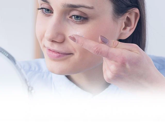  A woman placing a contact lens into her left eye